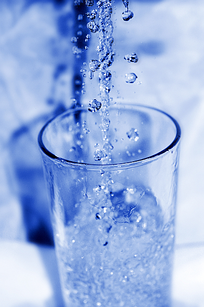 Trinkwasserglas sprudelnde Wasserperlen Tropfen