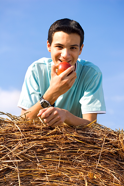 Junge beim Apfel essen Heu Stroh Natur