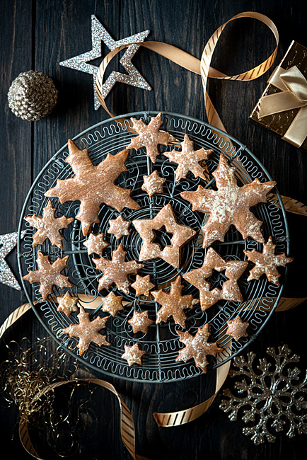 Schneeflocken und Eiskristalle Weihnachtsplätzchen sowie Sterne liegen auf einem nostalgischen  Draht Kuchengitter