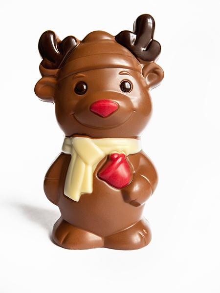 Süße Schokoladenfigur in Form von einem Baby-Hirsch oder Elch Rentier zu Weihnachten aus Vollmilchschokolade verziert mit dunkler, weisser und roter Schokolade.